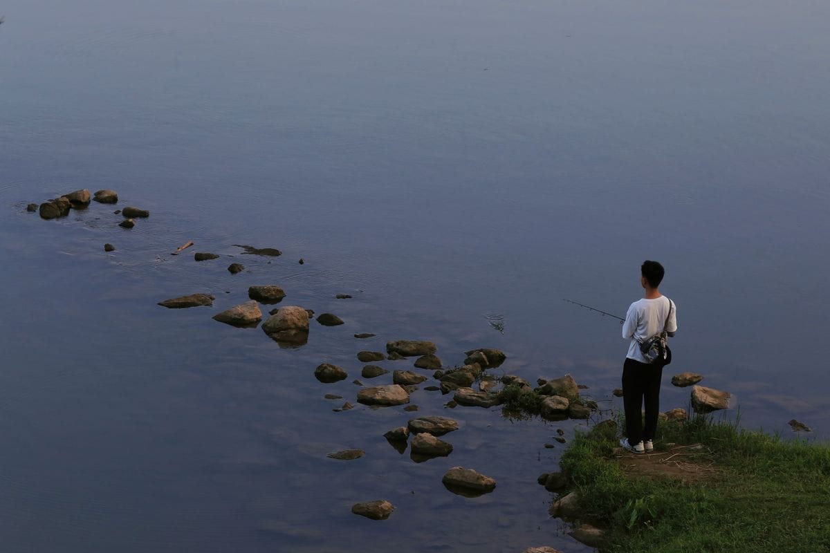 pescador practicando drop shot desde la orilla de un embalse