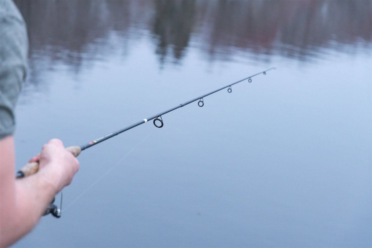 pesca vertical de lucioperca con caña sobre el agua